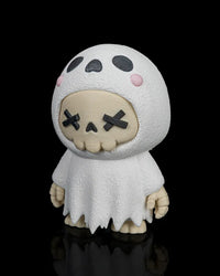 Angled front view of the white ghost skull figurine with black facial details and pink cheeks on a black background.