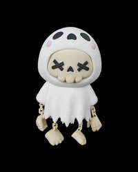 Front view of the white ghost skull figurine with dangling arms and feet on a black background.