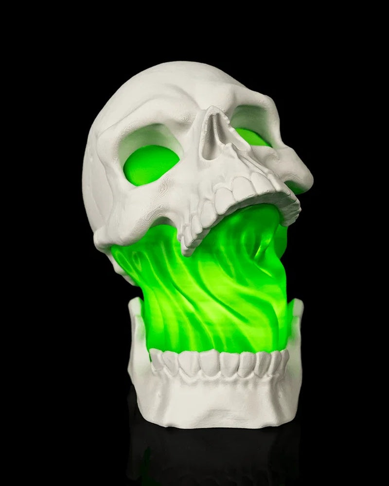Front view of a white skull lamp with green light showing through the eyes and open mouth