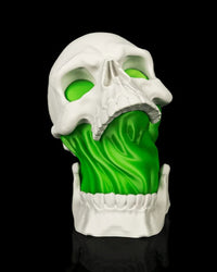 Front view of a white skull lamp with green glow inside the skull and jaw
