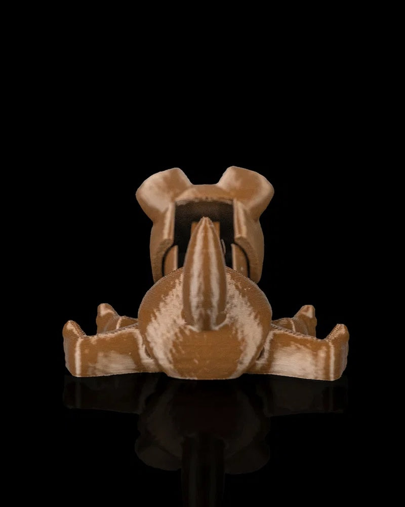 Rear view of a brown puppy toy with tail and outstretched legs on a dark surface