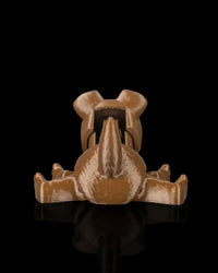 Rear view of a brown puppy toy with tail and outstretched legs on a dark surface