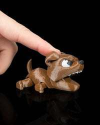 Finger pressing the head of a brown puppy toy with its mouth open