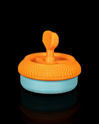 Orange and blue circular toy viewed from the back with a raised top grip on a black background