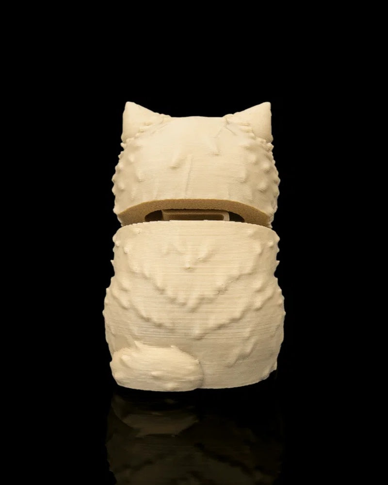Back view of a cream-colored seated cat figure with pointed ears and textured fur on a black background