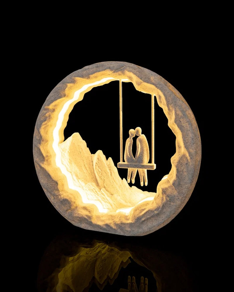Glowing round table lamp viewed from the front with two seated figures on a swing