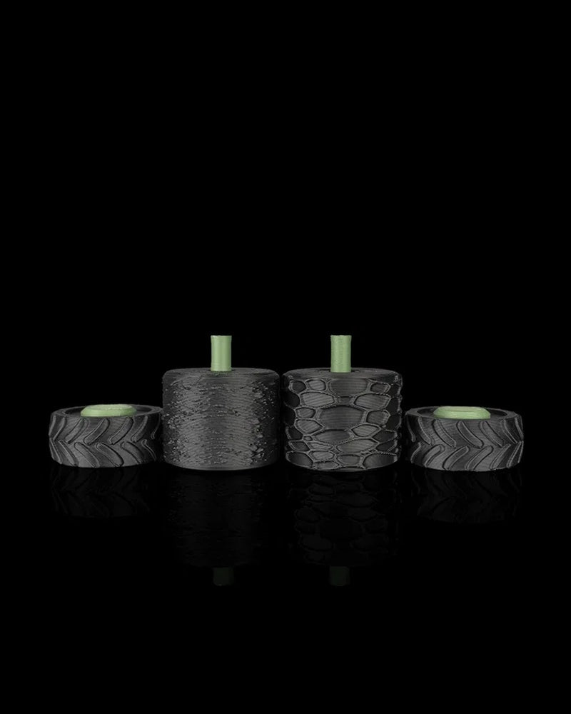 Four black rollers displayed in a row, including treaded wheel shapes and textured cylindrical rollers.