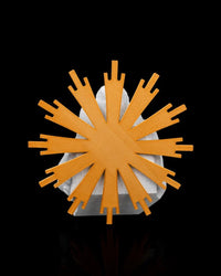 Back view of a white figurine with a large gold-tone radial backing