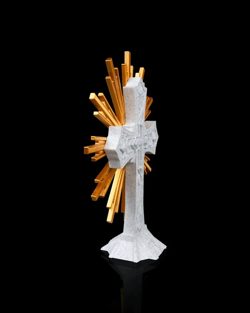 Side view of a white cross figurine with gold-toned rays behind it
