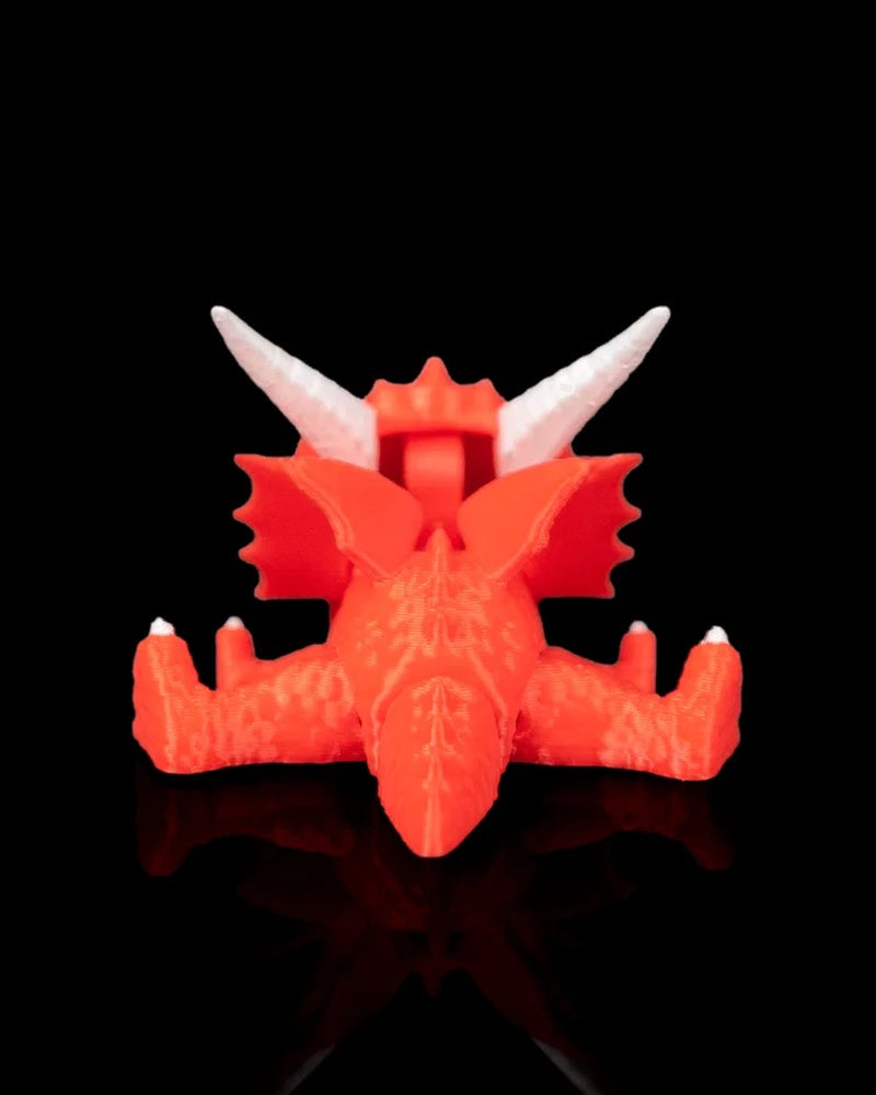 Rear view of a red dragon toy with white horns, red wings, legs, and tail