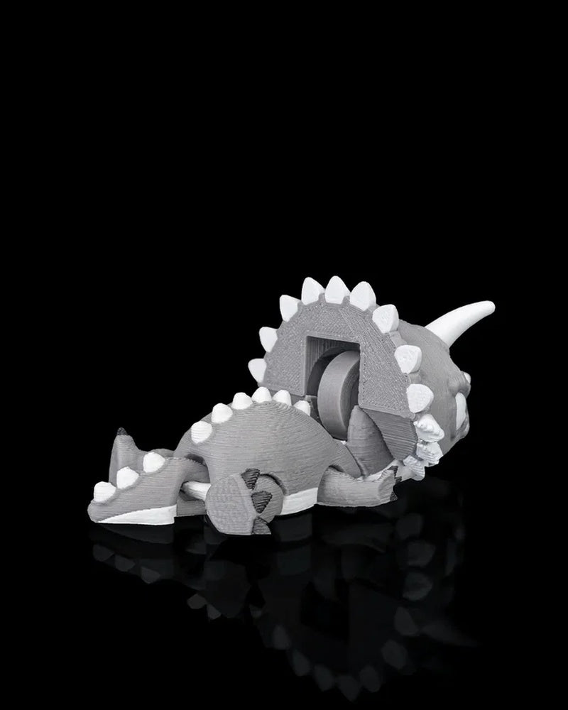 Rear view of a gray and white triceratops dinosaur toy with raised frill and tail