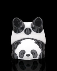 Front view of a black and white panda figurine with rounded ears and a smaller panda face detail