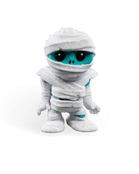 Front view of a white wrapped monster figurine with a turquoise face and large black eyes on a plain background.