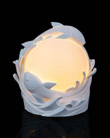 White fish and wave forms surround a glowing round center on a black background.