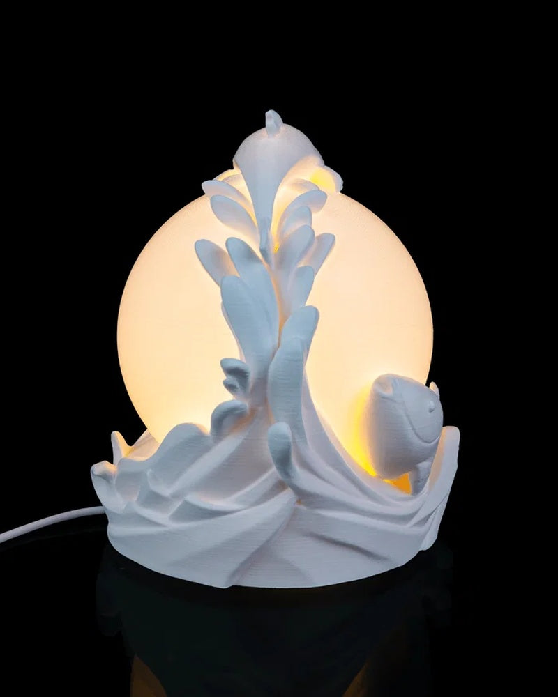 Side view of a white fish and wave lamp in front of a glowing round center.