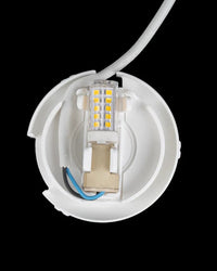 Open circular white base showing a small bulb with yellow elements and wires.