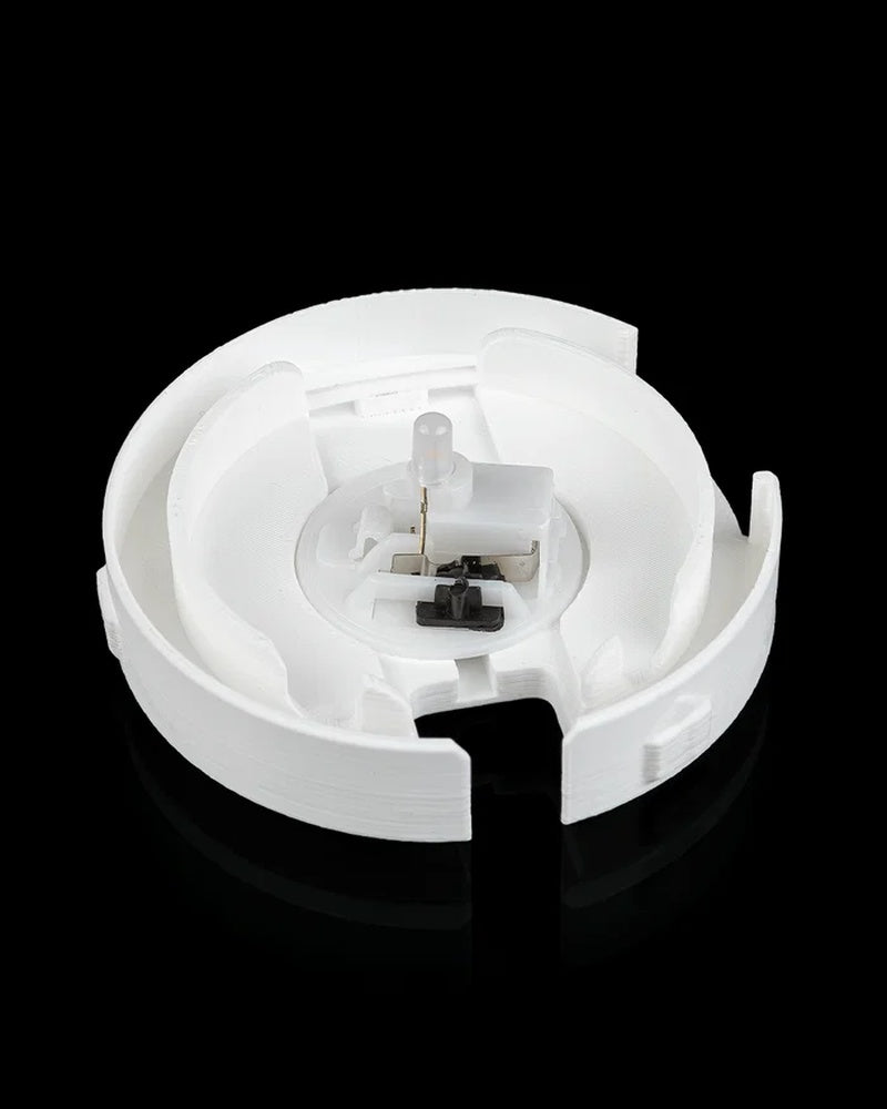 Open circular white base showing a small clear bulb and a black switch.