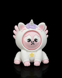 Front view of a white unicorn axolotl character with a sad pink face, purple mane, horn, pink frills, and yellow star accent on a black background