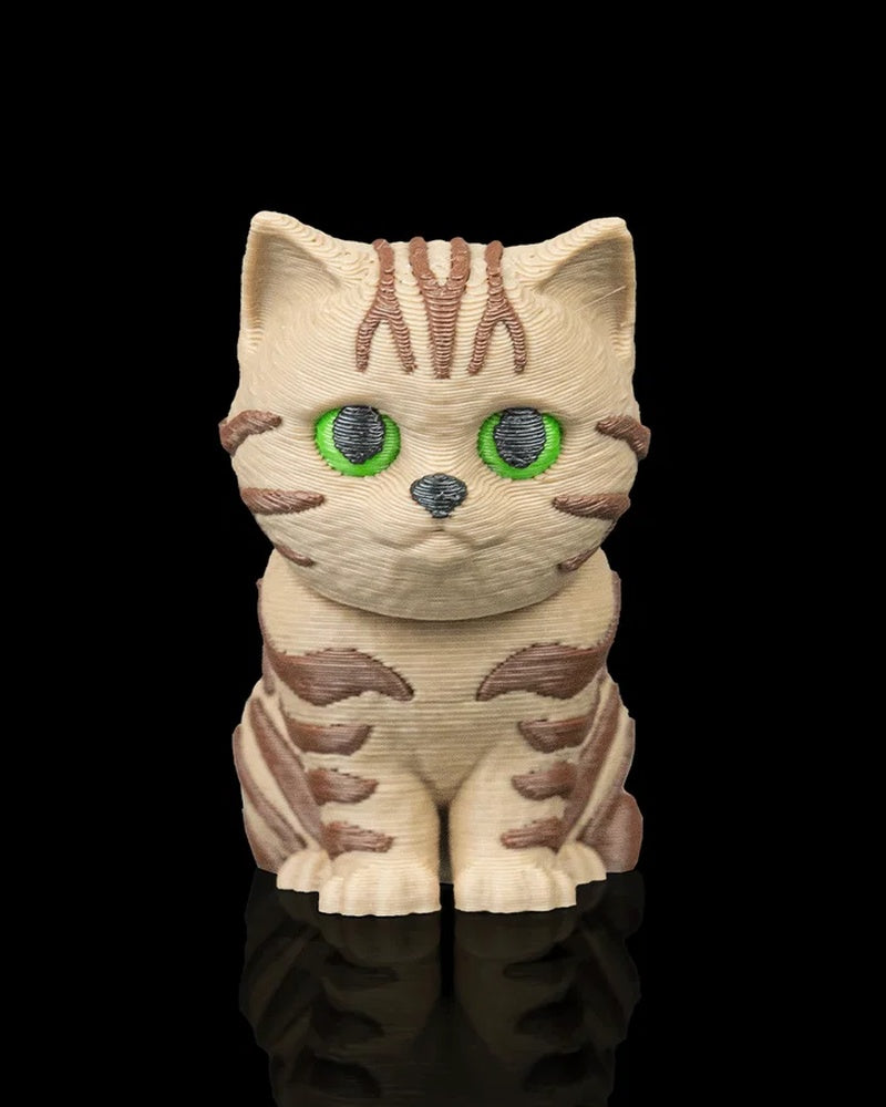 Front view of a cream and brown tabby cat figurine with green eyes