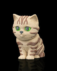 Angled front view of a cream and brown tabby cat figurine with green eyes