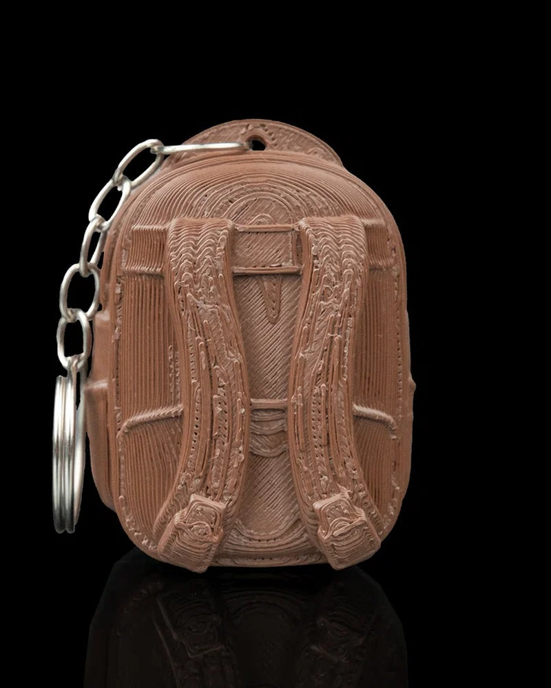 Back view of a brown backpack-shaped carrier with straps and a metal ring and chain