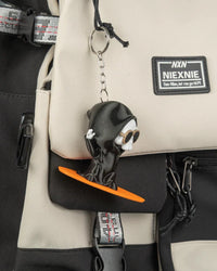Small hooded ghost charm hanging from a metal ring and chain on a bag