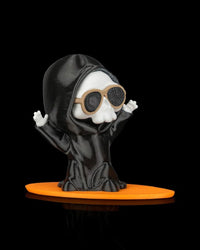 Ghost figurine with raised hands, sunglasses, and an orange board base on a black background