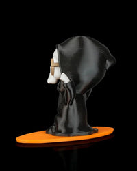 Side view of a hooded ghost figurine with tan sunglasses and an orange base