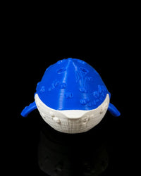 Front view of a blue and white whale figurine with raised surface details