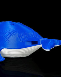Close-up of the side of a blue and white whale figurine with a rectangular opening
