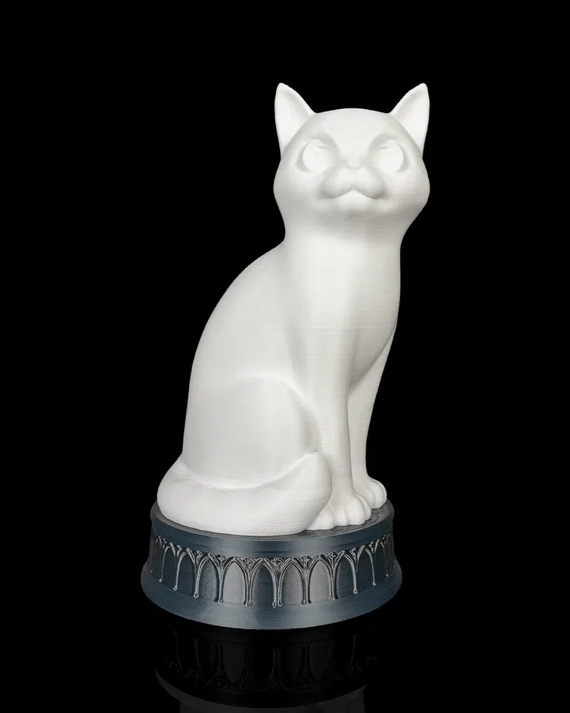 White cat-shaped lamp on a dark round base against a black background
