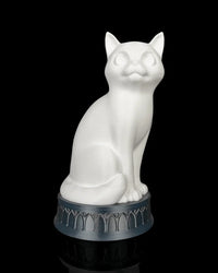 White cat-shaped lamp on a dark round base against a black background